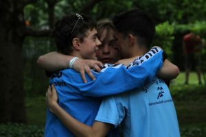 Drei Jungs umarmen sich nach dem Staffel-Lauf
